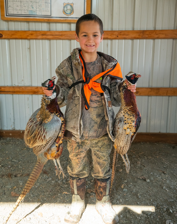 Youth holding harvested pheasants