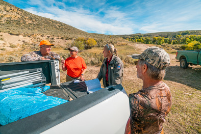 Game warden and hunters interacting