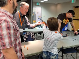 Hunters education class, student taking weapons safety class with instructors